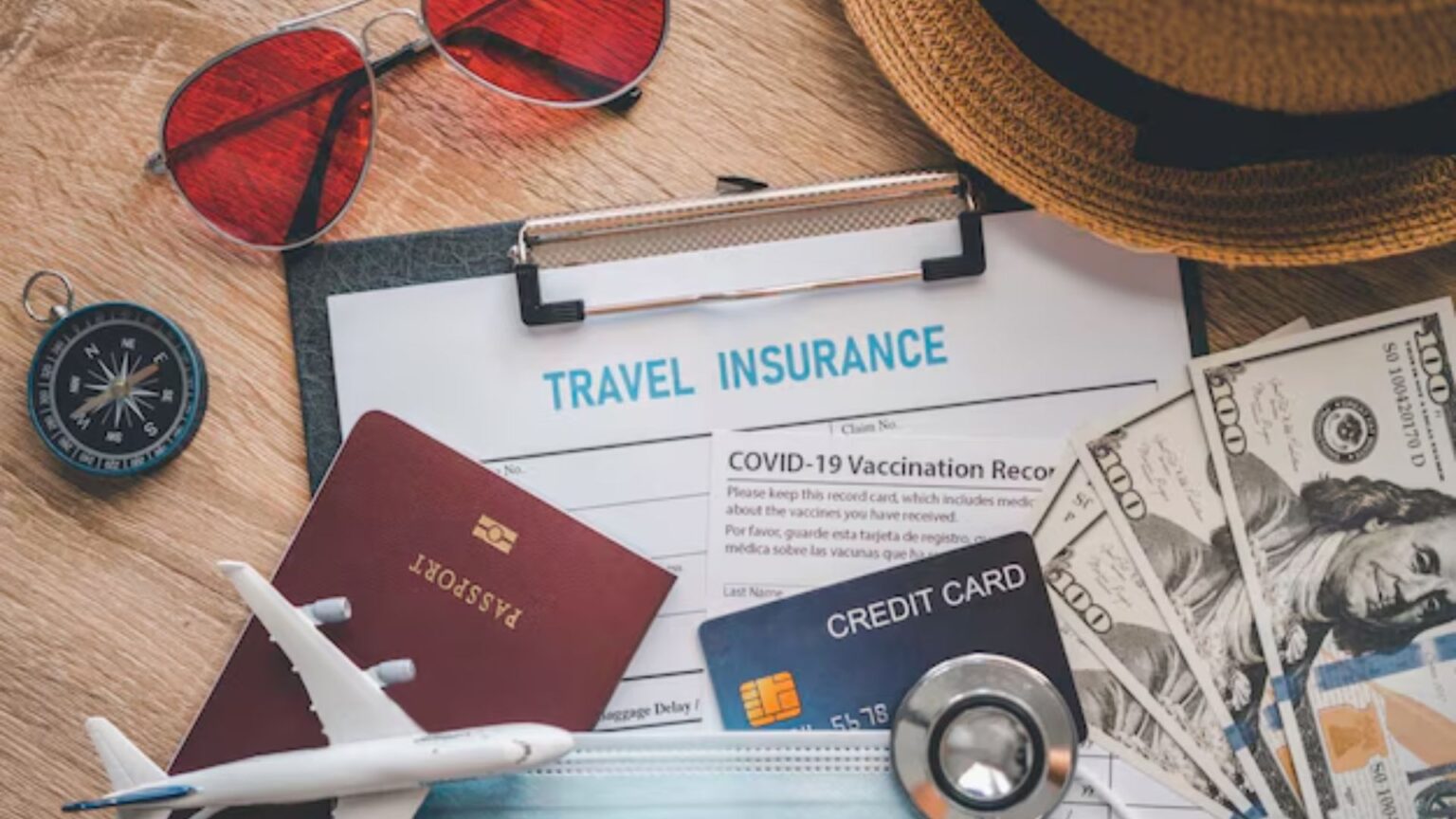 Passport, credit card, cash, and travel isnurance policy on a table