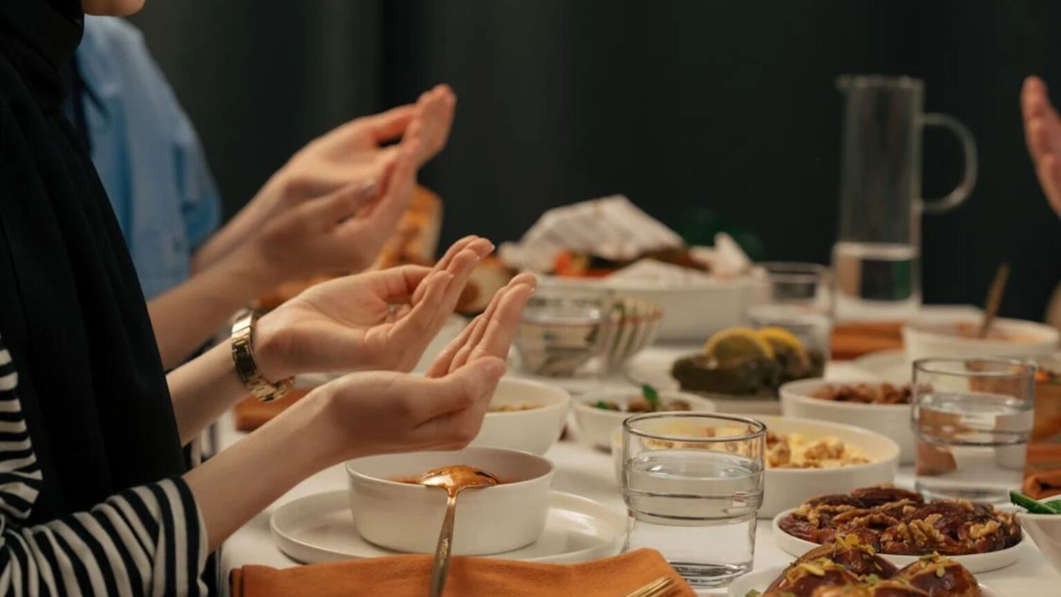 Hands in prayer over table of food