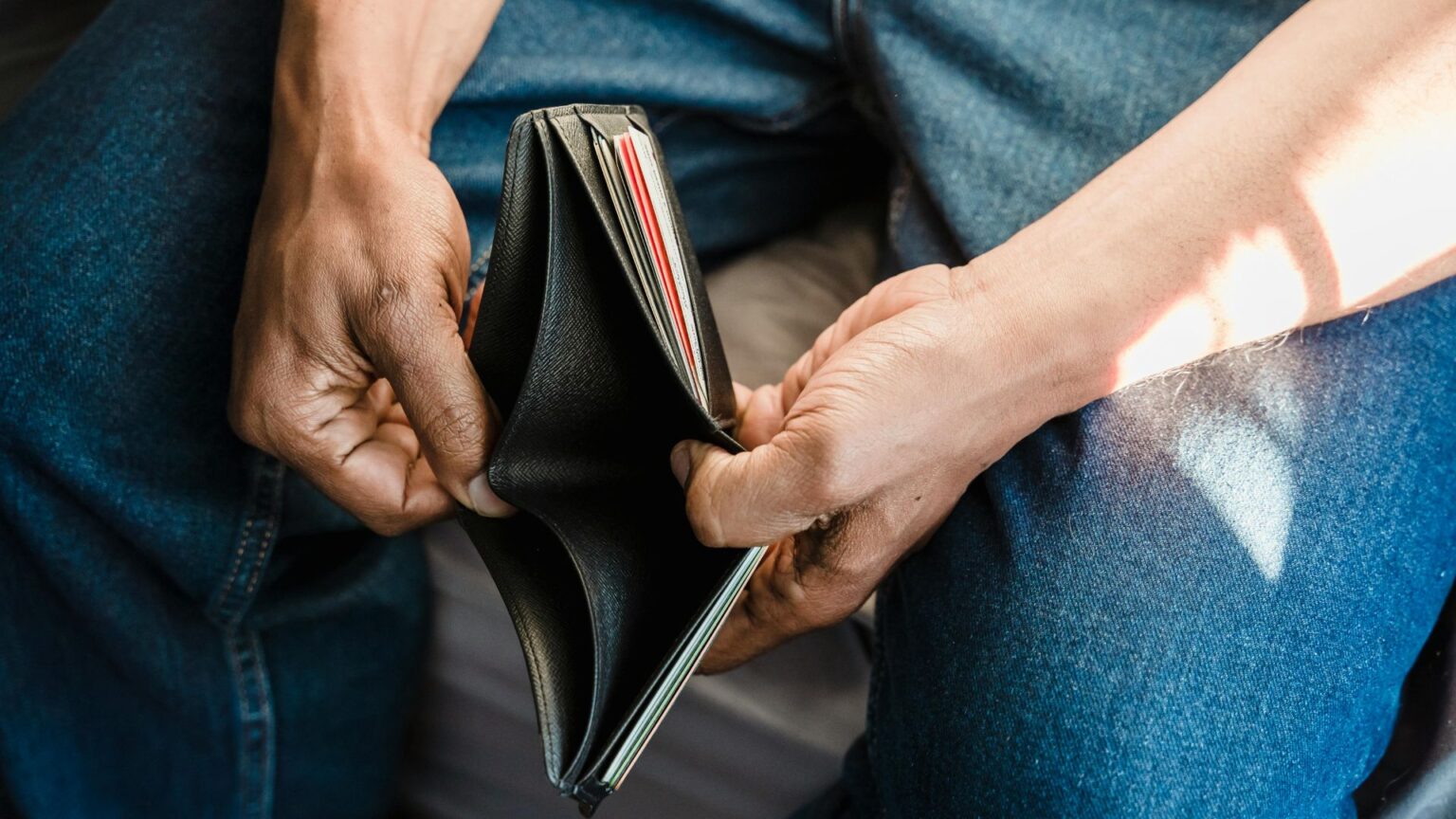 Man opening empty wallet